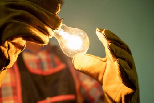 électricien Castanet-Tolosan - un artisan tient une ampoule allumée