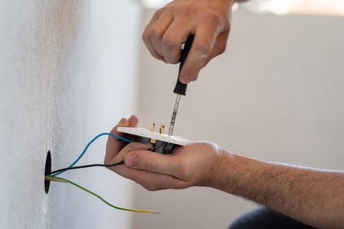 électricien La Ciotat - un homme installe une prise électrique