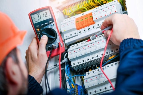 électricien Méricourt - un artisan électricien inspecte un tableau électrique