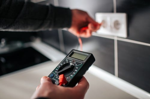 électricien Tournefeuille - un homme vérifie le voltage d'une prise