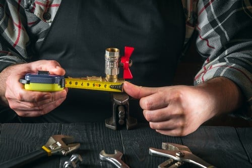 plombier Ambarès-et-Lagrave - un artisan fait des mesures sur des circuits de plomberie