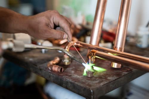 plombier Berre-L'étang - un artisan soude un circuit de plomberie en cuivre