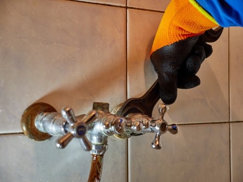 plombier Dijon - un artisan démonte un vieux robinet
