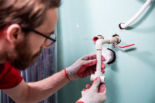 Plombier Libourne - Un plombier refait les circuits d'eau.