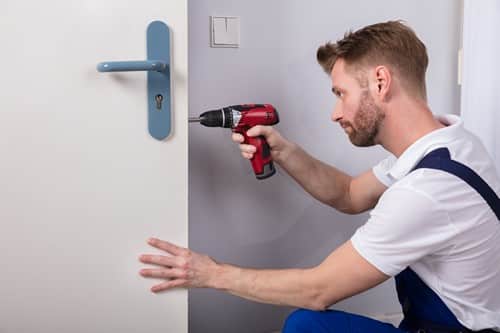 serrurier Castelnau-le-Lez - un ouvrier pose une serrure sur une porte neuve