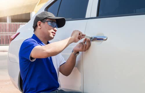 serrurier Écully - un artisan crochète une porte de voiture