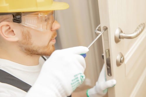 serrurier Genas - un artisan installe une poignée de porte