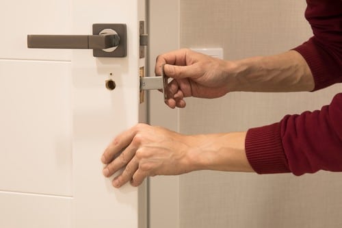 serrurier Harnes - une personne installe une poignée de porte