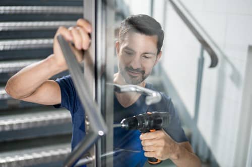 serrurier Sallaumines -un artisan installe la poignée d'une porte