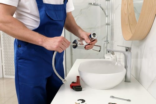 Plombier Aix-les-Bains - un artisan installe un robinet.