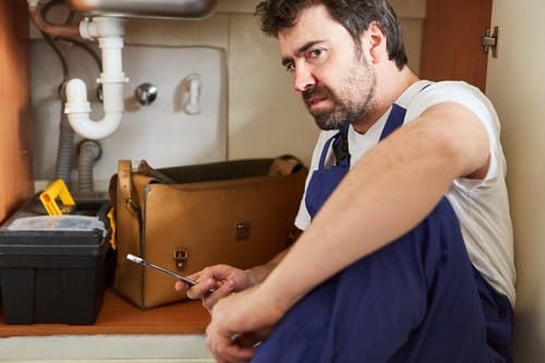 Plombier Dreux - un artisan répare un siphon.