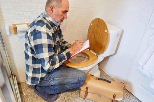 Plombier Saumur - un artisan plombier prend des notes.