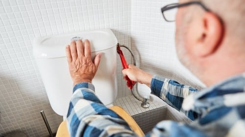 Plombier Vallauris - Un artisan répare des toilettes.