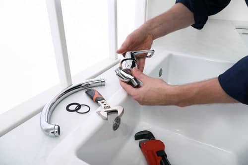 Plombier Vierzon - Un artisan installe un robinet.