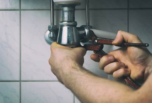 plombier La Celle-Saint-Cloud - un homme dévisse la bonde d'un évier