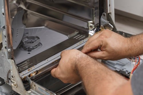 plombier Le Grand-Quevilly - Un technicien installe un lave vaisselle.