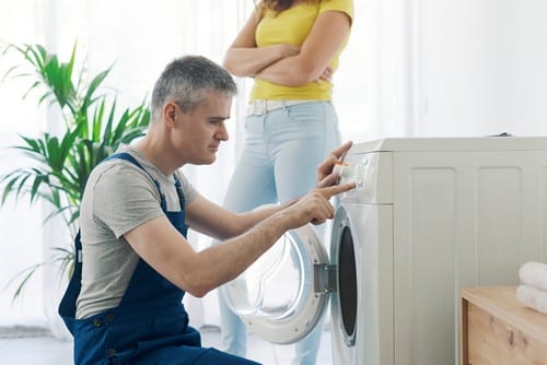 plombier Mandelieu-la-Napoule - Un artisan répare une machine à laver.