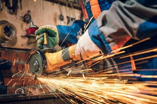 serrurier Bruges - un serrurier fait une découpe à la scie circulaire dans son atelier.