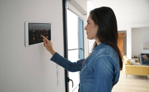 chauffagiste Alès - Une femme règle la température de sa maison.