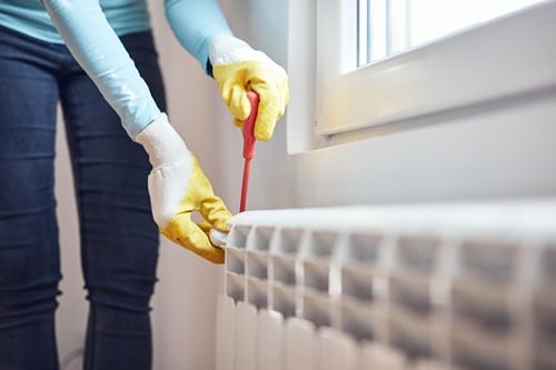 chauffagiste Bezons - Un plombier chauffagiste répare un radiateur