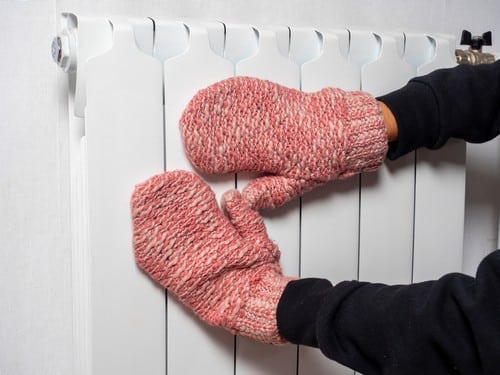 chauffagiste Laon - Se réchauffer les mains sur le radiateur