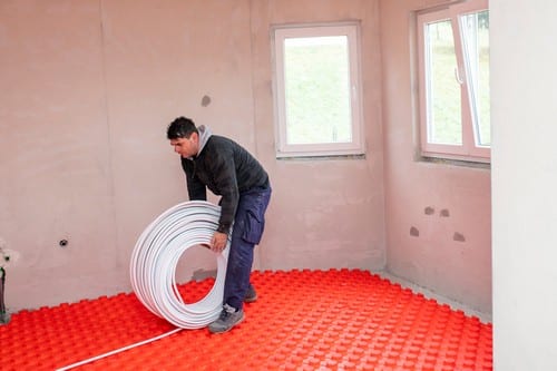 chauffagiste Le Chesnay - Un artisan installe un plancher chauffant.