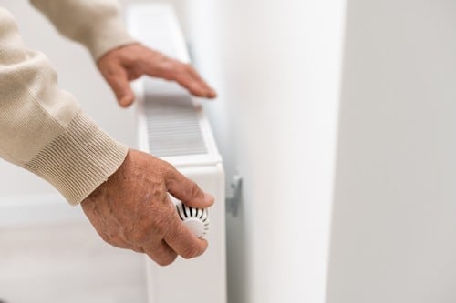 chauffagiste Maubeuge - Un homme règle la température de son radiateur