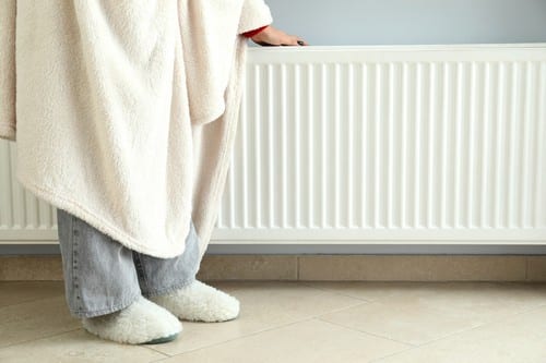 chauffagiste Mont-de-Marsan - Le radiateur réchauffe les mains de la femme