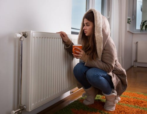 chauffagiste Montigny-le-Bretonneux - Une femme à côté d'un radiateur.