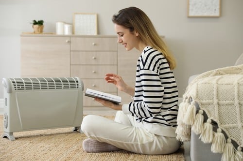 chauffagiste Pontarlier - une femme lit devant son radiateur