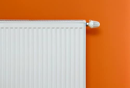 chauffagiste Savigny-sur-Orge - Un radiateur sur fond orange.