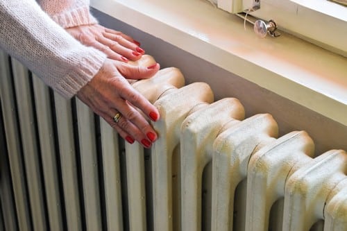 chauffagiste Six-Fours-les-Plages - Une femme à côté d'un radiateur.