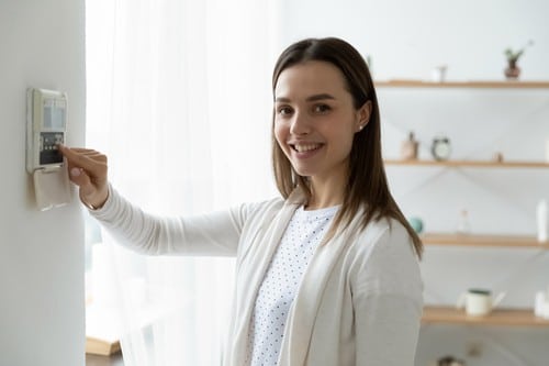 chauffagiste Sotteville-lès-Rouen - Une femme règle la température de son intérieur.