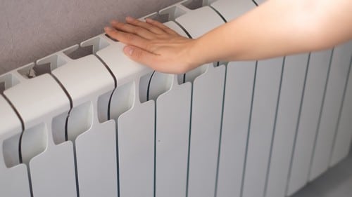 chauffagiste Thonon-les-Bains - Une main sur un radiateur chaud