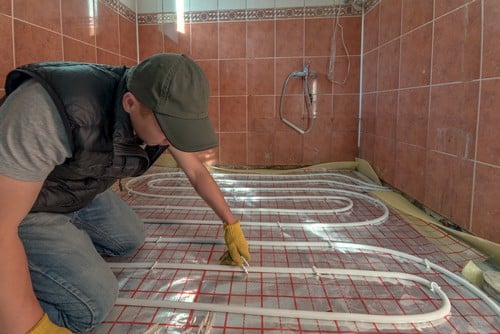 chauffagiste Valenciennes - Un artisan installe un plancher chauffant.