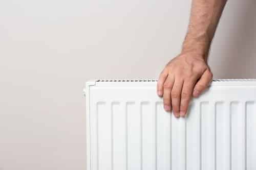 chauffagiste Vélizy-Villacoublay - Se réchauffer les mains sur son radiateur