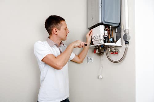 chauffagiste Villemomble - Un plombier électricien répare un chauffe eau