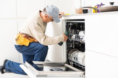 plombier Agde - Un technicien répare un lave vaisselle.