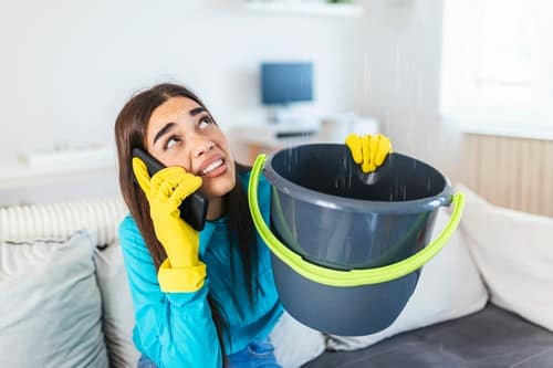 sous-traitance plomberie - une femme constate une fuite d'eau, elle a besoin d'un chantier de plomberie