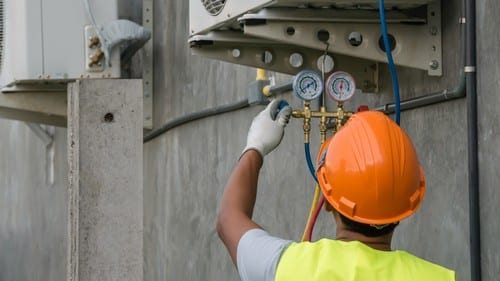 plombier Moulins - un plombier chauffagiste installe une unité extérieure de climatisation