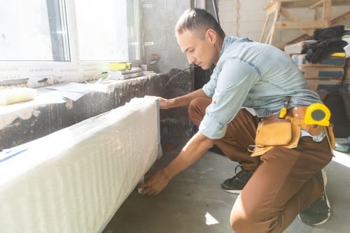 plombier Ozoir-la-Ferrière - Un artisan installe un radiateur.