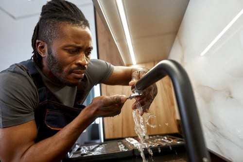 plombier Saint-Michel-sur-Orge - Un jeune artisan répare un mitigeur.