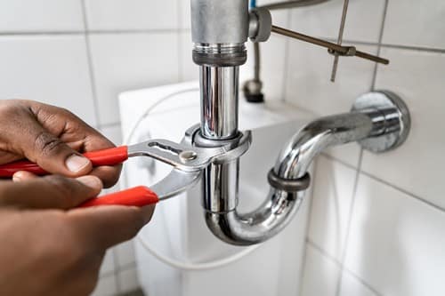 plombier Sotteville-lès-Rouen - un artisan répare l'arrivée d'eau d'une baignoire.