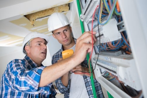 électricien Auch - Deux électriciens règlent un tableau électrique