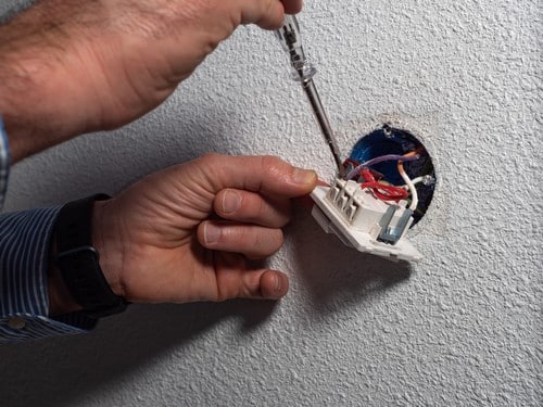 électricien Chaumont - Un électricien répare une prise électrique