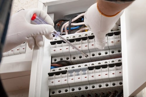 électricien Fleury-les-Aubrais - Un électricien change les réglages du tableau électrique