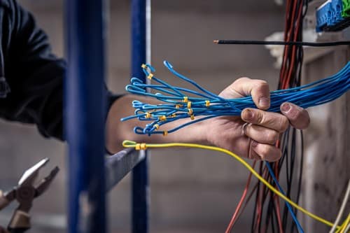 électricien Fontaine - Un électricien ajuste les câbles électriques