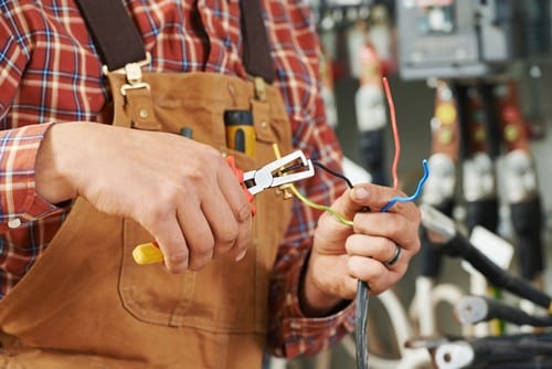 électricien Fresnes - les bons artisans - électricien avec une pince et des fils électriques