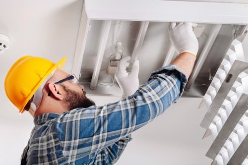 électricien Herblay - Un électricien finalise la pose de lampe au plafond