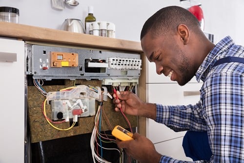 électricien La Courneuve - un artisan répare un four électrique